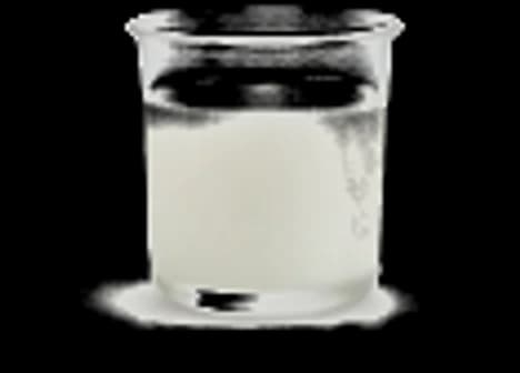 Glass beaker of translucent white tackifier binder